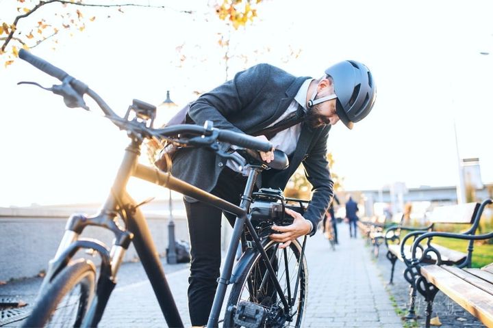 business man setting up electric bicycle for commute