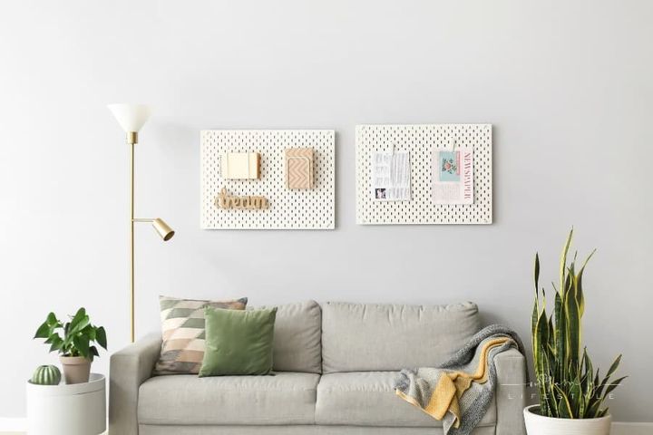 Comfortable Sofa near Grey Wall with Pegboards in Living Room Interior