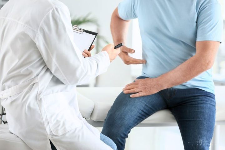 male patient explaining side pain to a male doctor