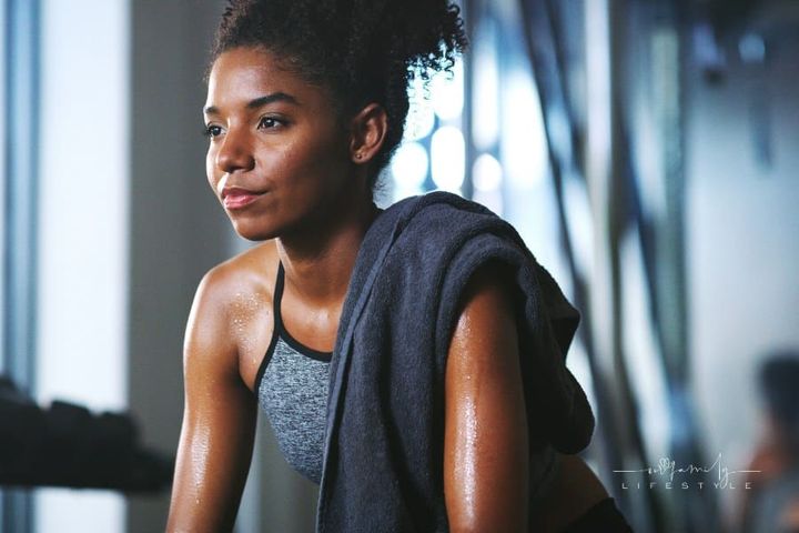 Shot of a sporty young woman taking a break while exercising at the gym