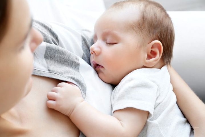 mom holding sleeping baby in her arms
