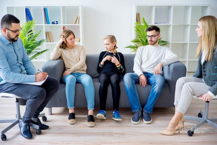 family with teen daughters in therapy session