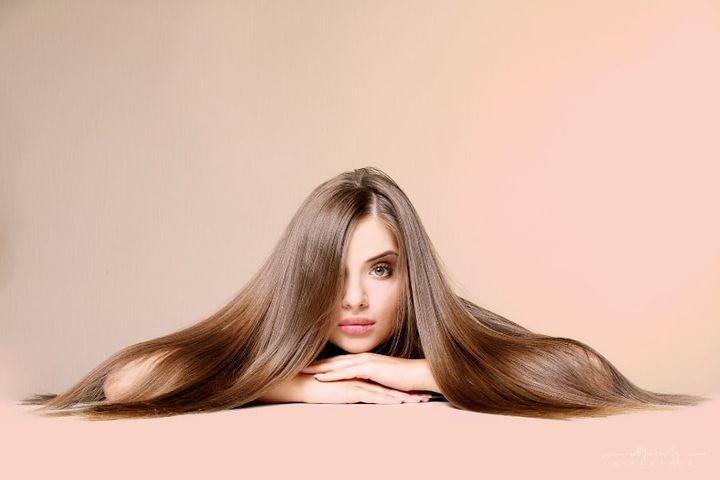 woman with long, healthy brown hair on colored background