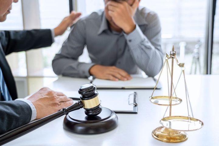 Male lawyer giving sad male client a pat on the back