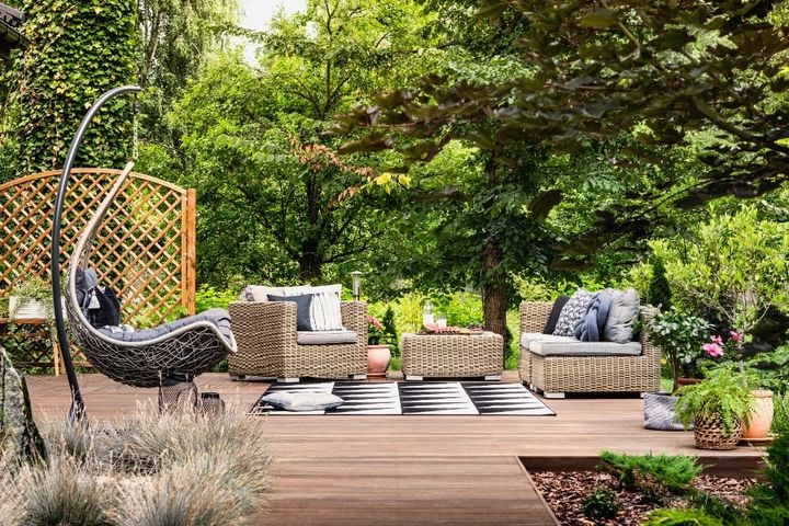 hanging chair and geometric outdoor rug on wooden patio