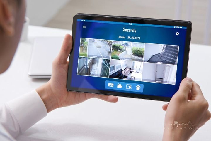 Man Watching Home Security Cameras on Tablet