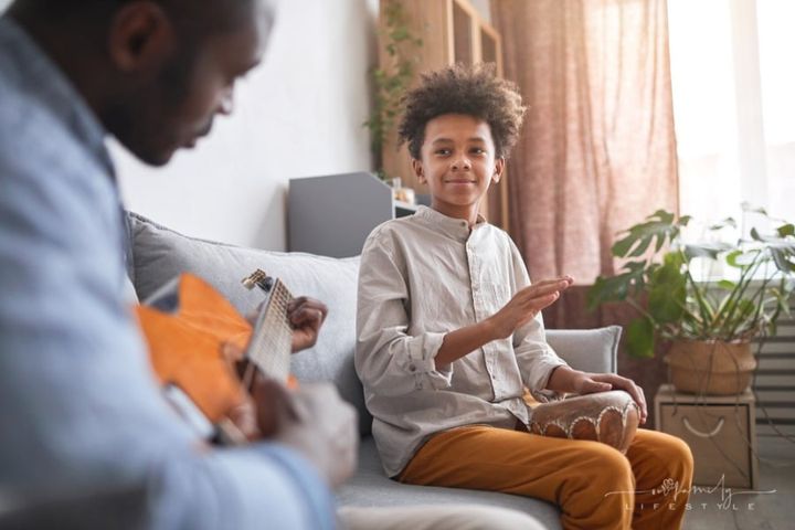 caring father and teenage son spending time together making music