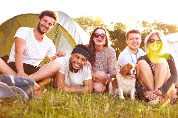 friends laughing outside of tent while camping