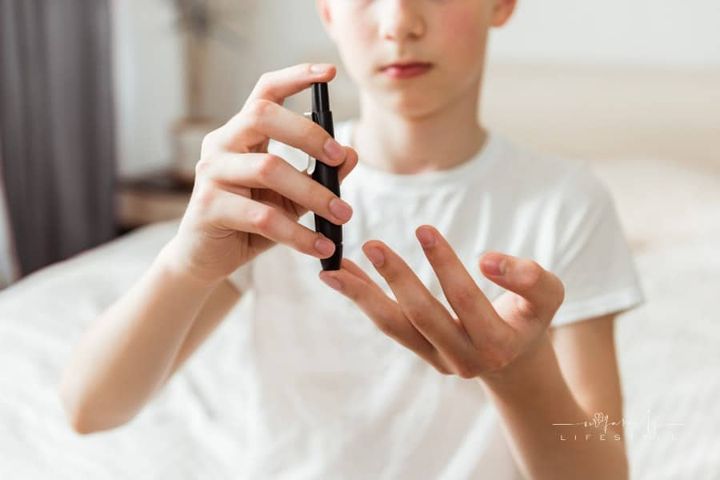 teen using a glucometer to check blood sugar levels for diabetes