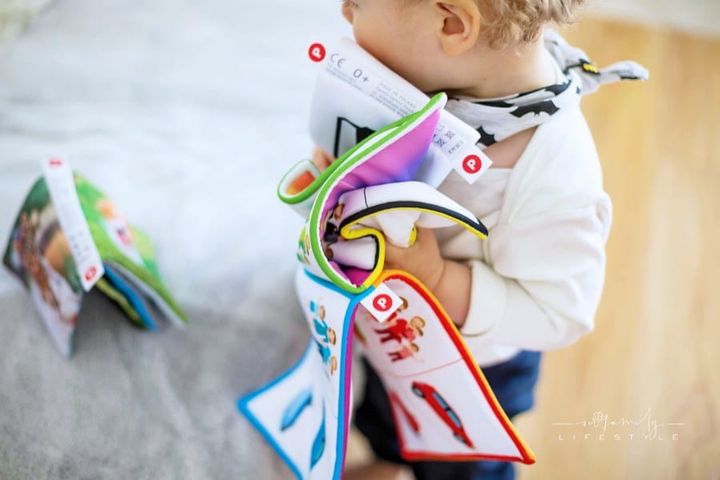 toddler carrying a soft plush book