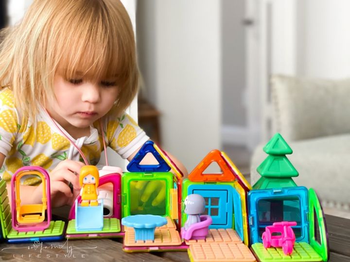 toddler taking pictures of her Magformers creation