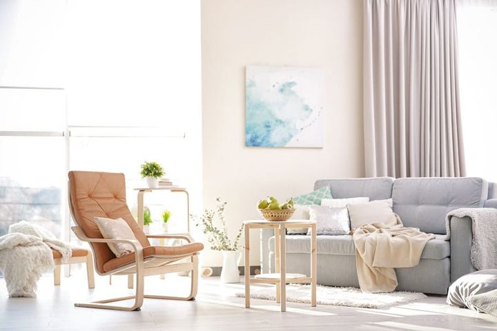 cozy modern living room with large windows for natural lighting and pops of color with pears and home accents