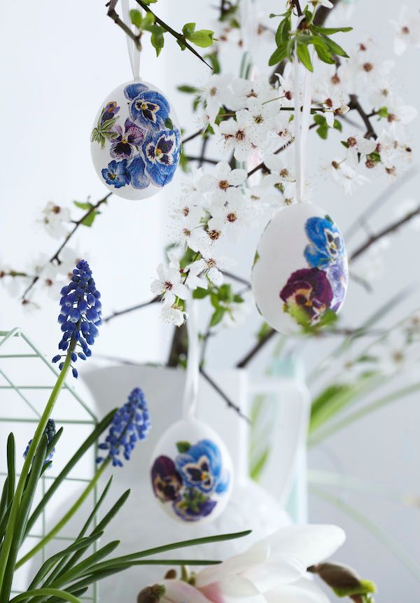 Dainty decoupaged eggs hanging from delicate branches.