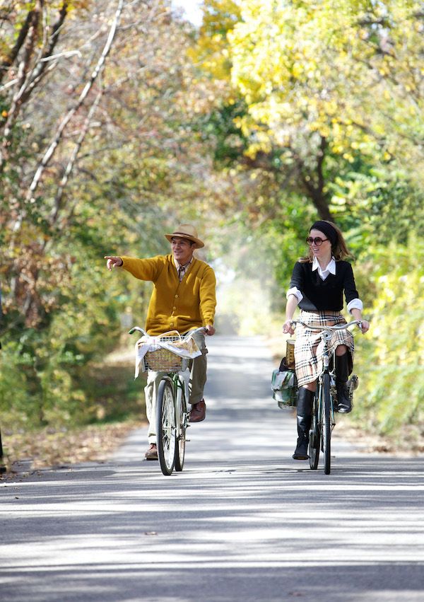 A couple heading to a picnic on vintage bikes.