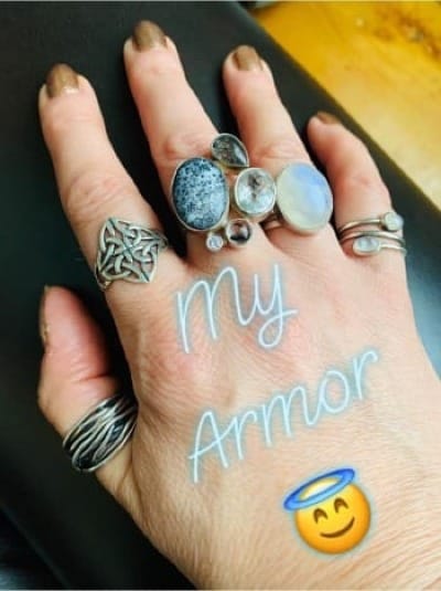 Close-up of a woman’s hand wearing multiple rings and meaningful jewelry described as “my armor,” symbolizing inner strength, feminine empowerment and confidence while building income from home.