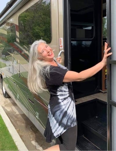 Roxanne Lynch smiling at motorhome doorway, reflecting the freedom to make money from home or while traveling with an online business