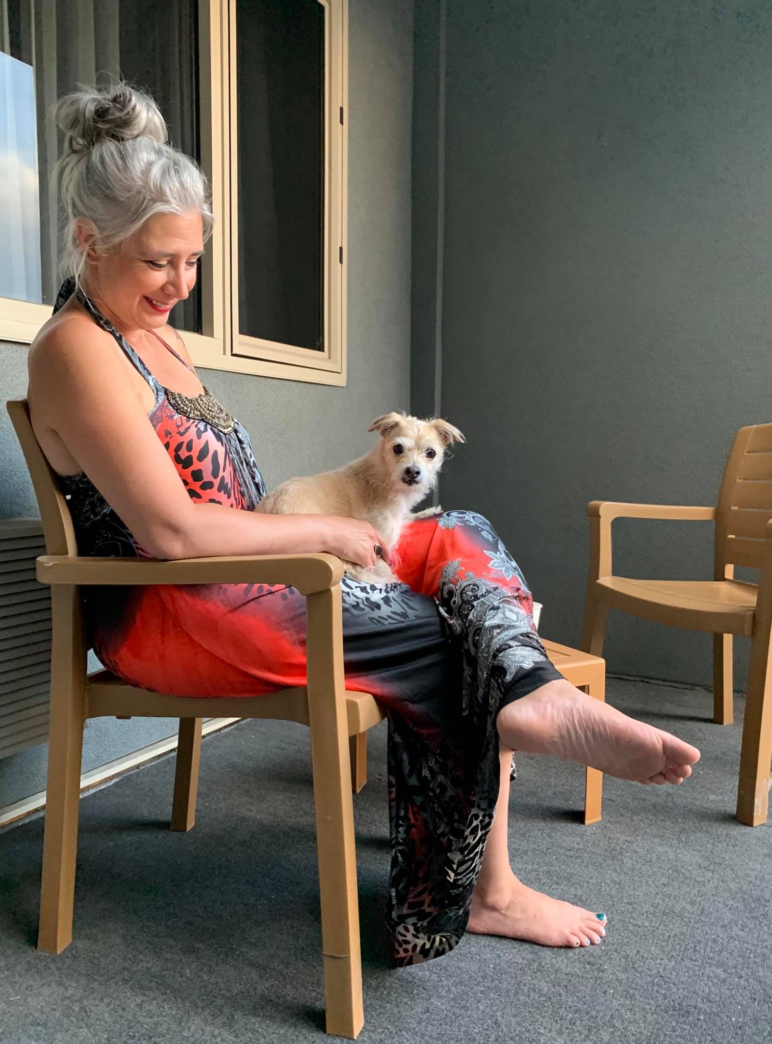 Roxanne Lynch sitting on a patio with her small dog, reflecting on finding legitimate ways to make extra money from home with more freedom, common sense, and trust.