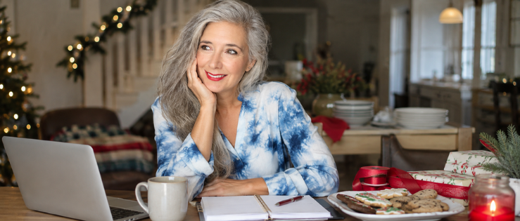 Gen X woman Roxanne Lynch planning holiday work beside a laptop, cookies and Christmas wrapping.