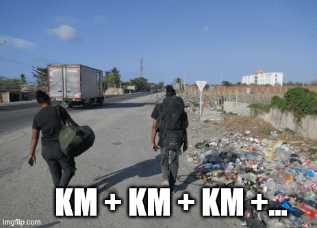 Deux personnes avec des sacs à dos marchent le long d'une route à Barranquilla en Colombie