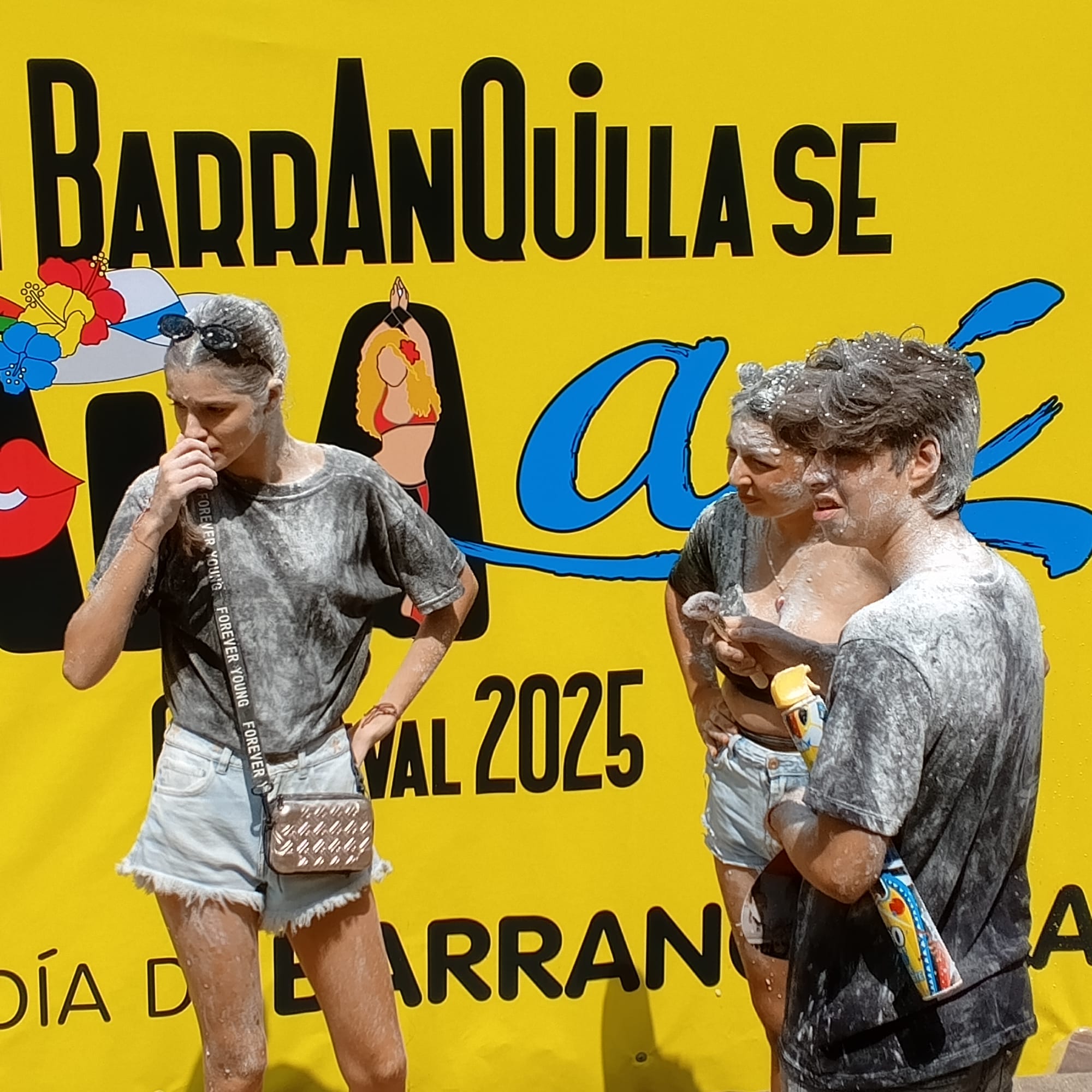 Trois jeunes aux vêtements plein de farine au carnaval de Barranquilla en Colombie.