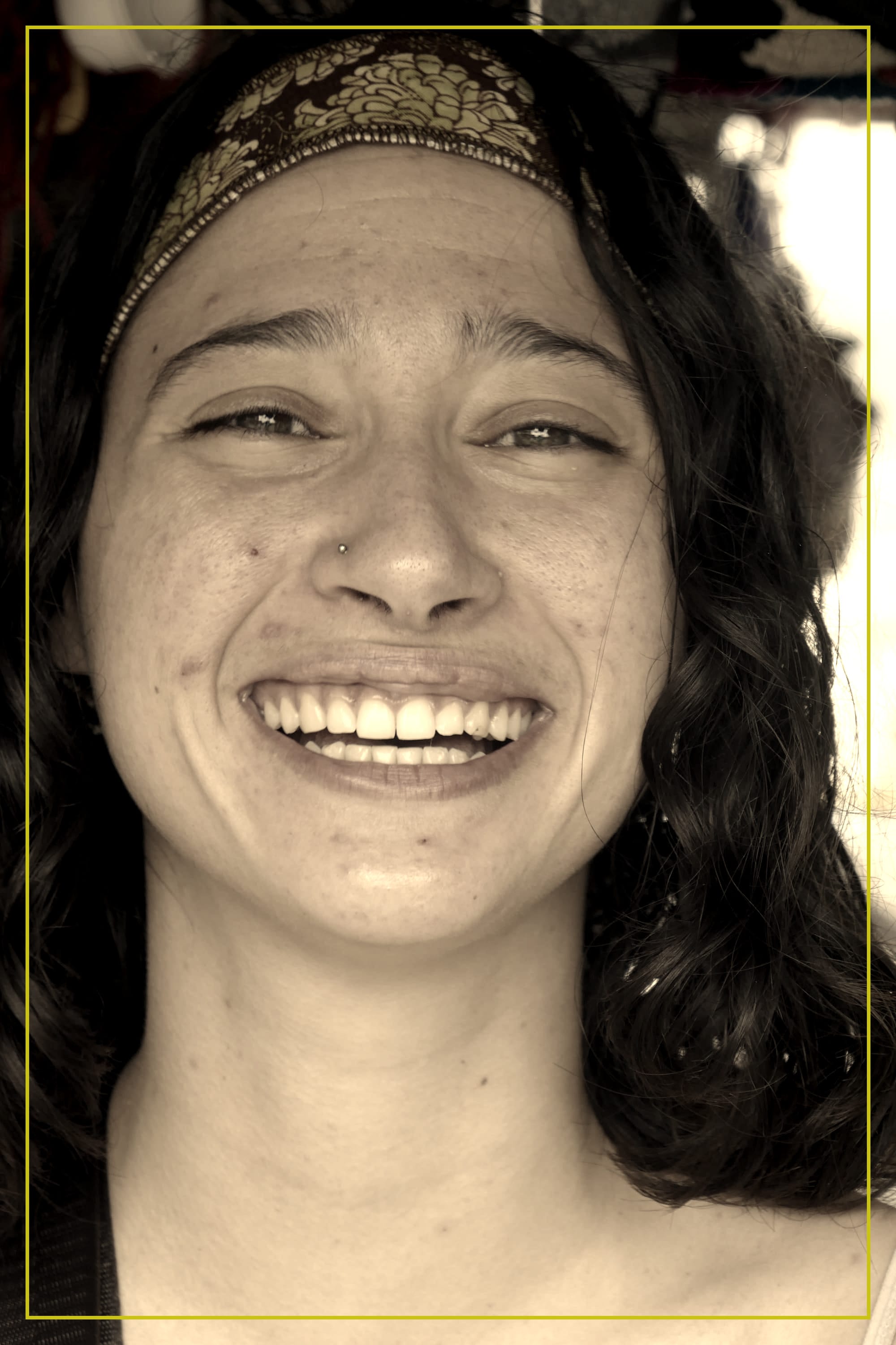 Femme avec un bandeau dans les cheveux qui sourit.