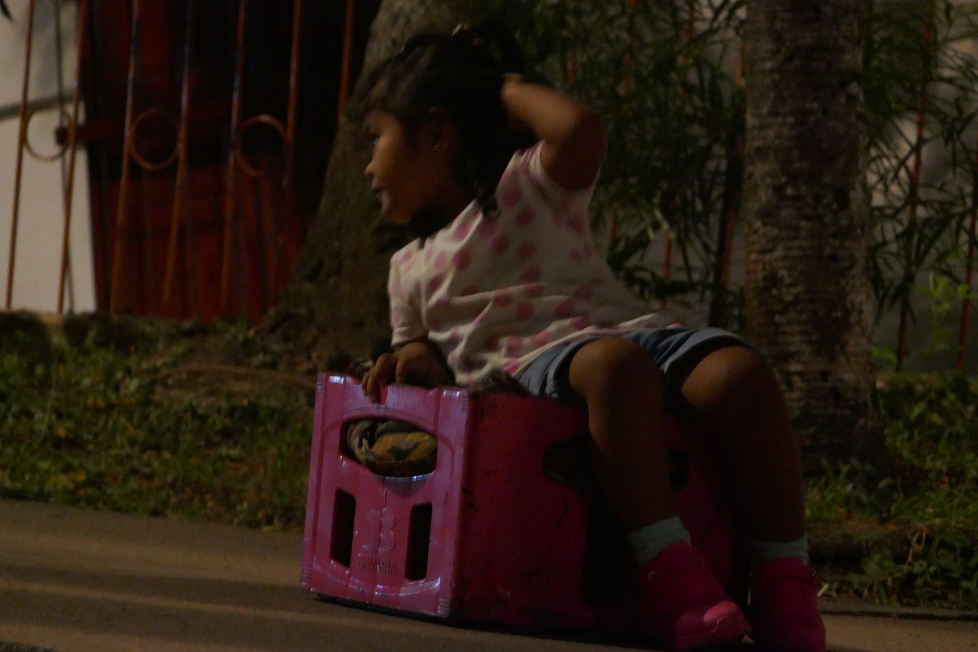 Petite fille sur une caisse vide qui attend à Cali.