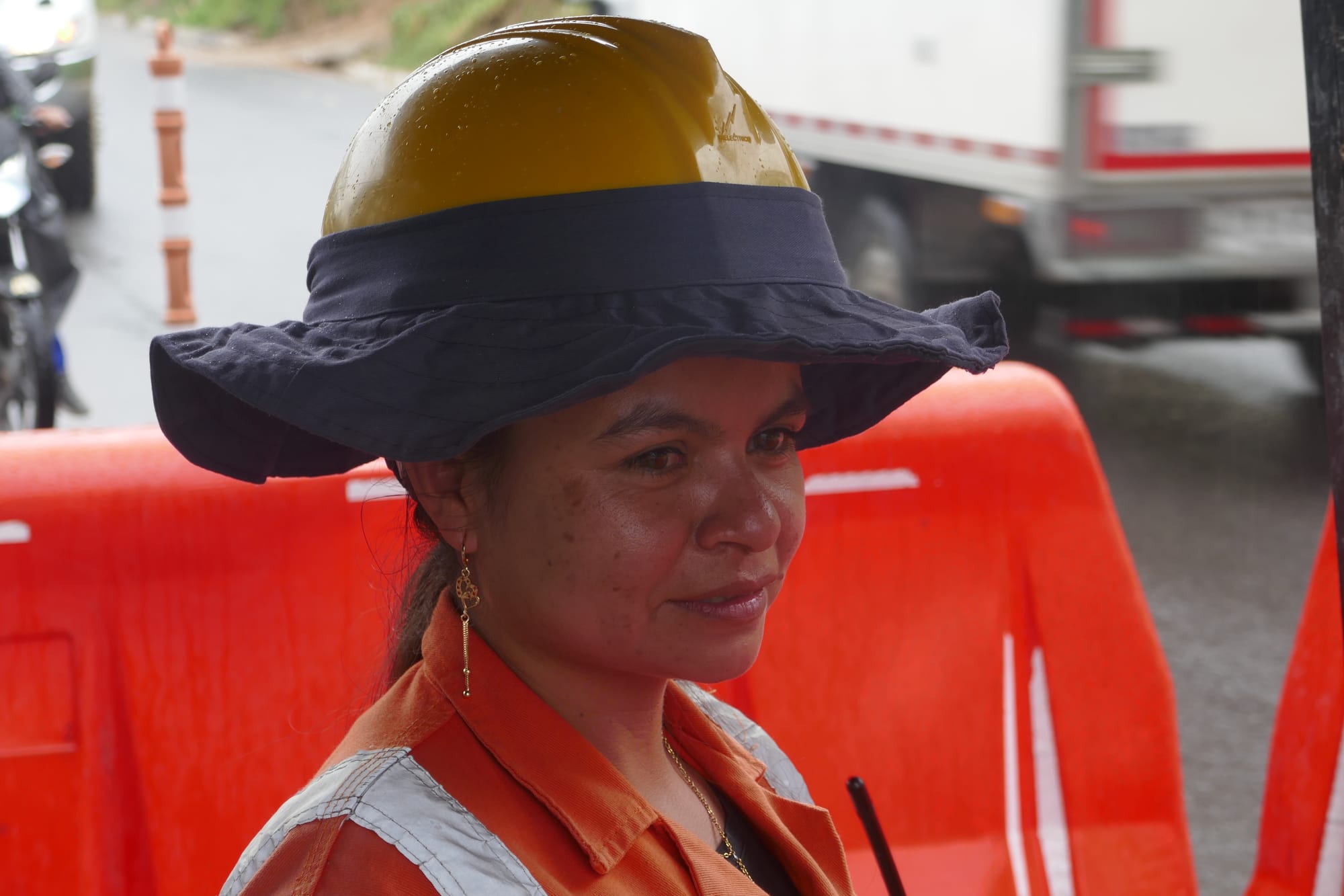 Une femme avec un casque de chantier régule la circulation à Mocoa en Colombie.
