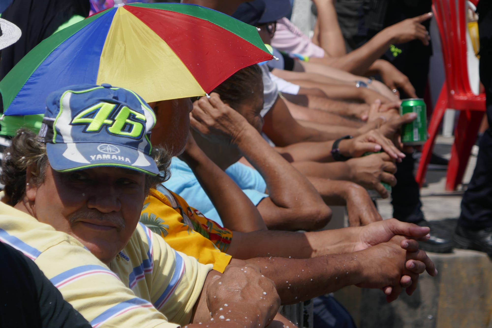 Plusieurs personnes derrière une barrière regardent un défilé au carnaval de Barranquilla en Colombie