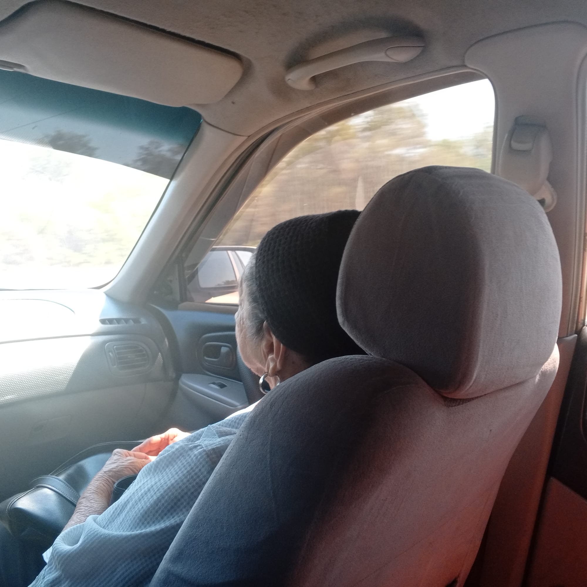 Une vieille dame est assise dans un taxi au Vénézuela.