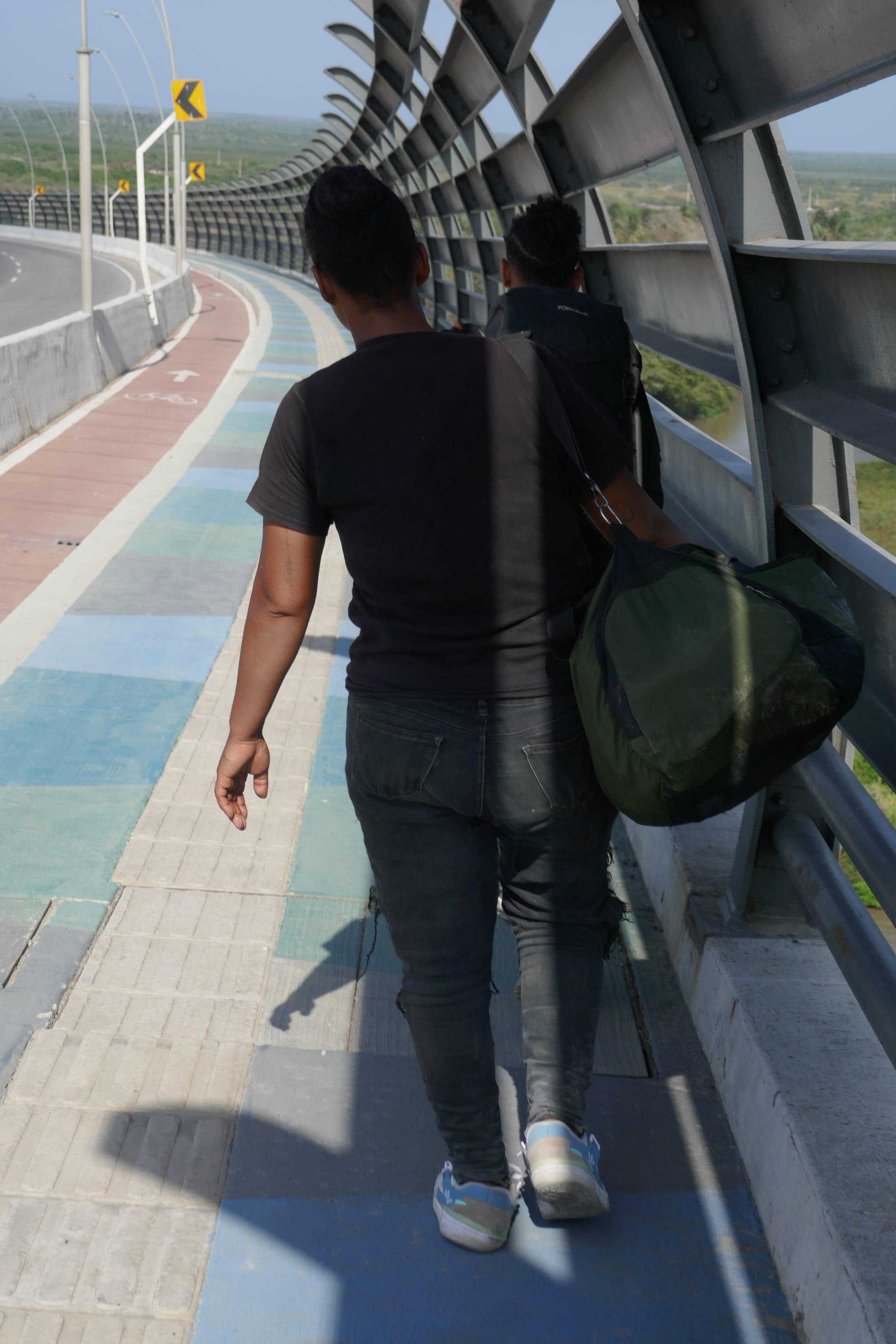 Une femme et un homme de dos traversent un pont à Barranquilla en Colombie.