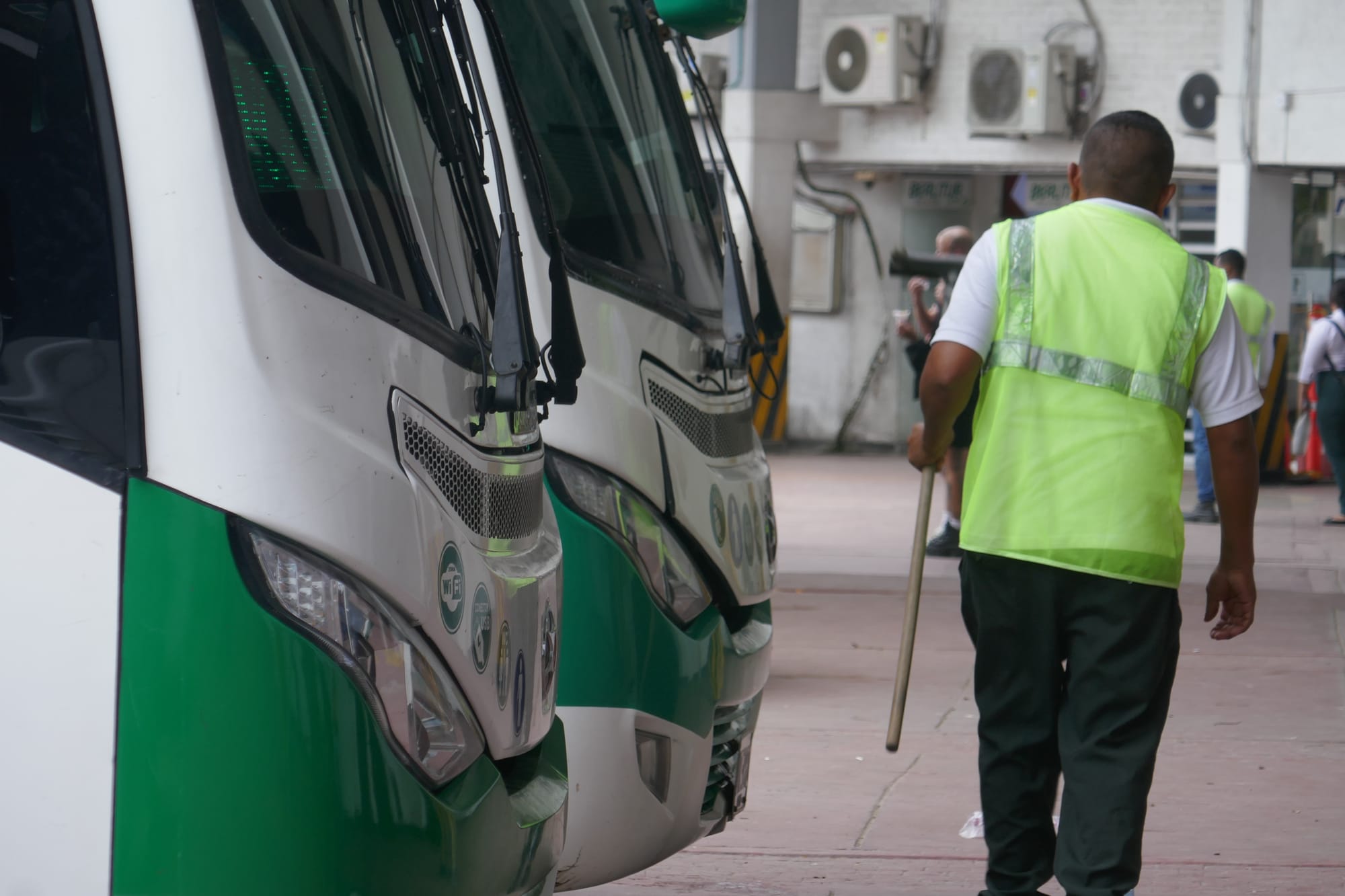 Un homme se tient près d'un bus dans une gare routière en Colombie.