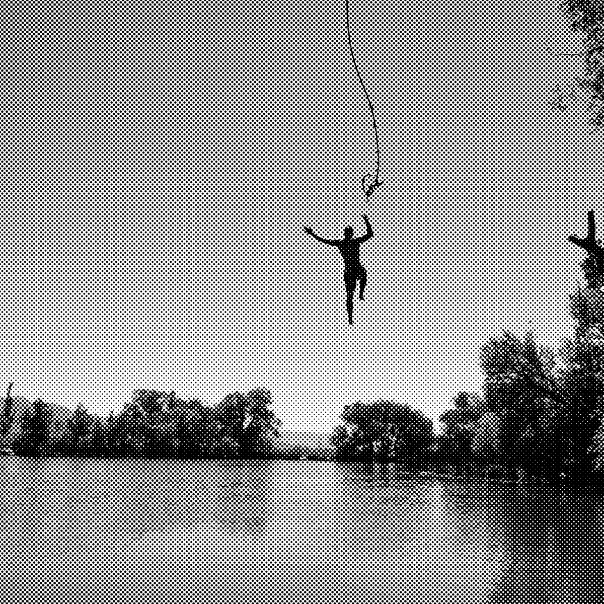 A person making a huge jump into a lake off a rope swing