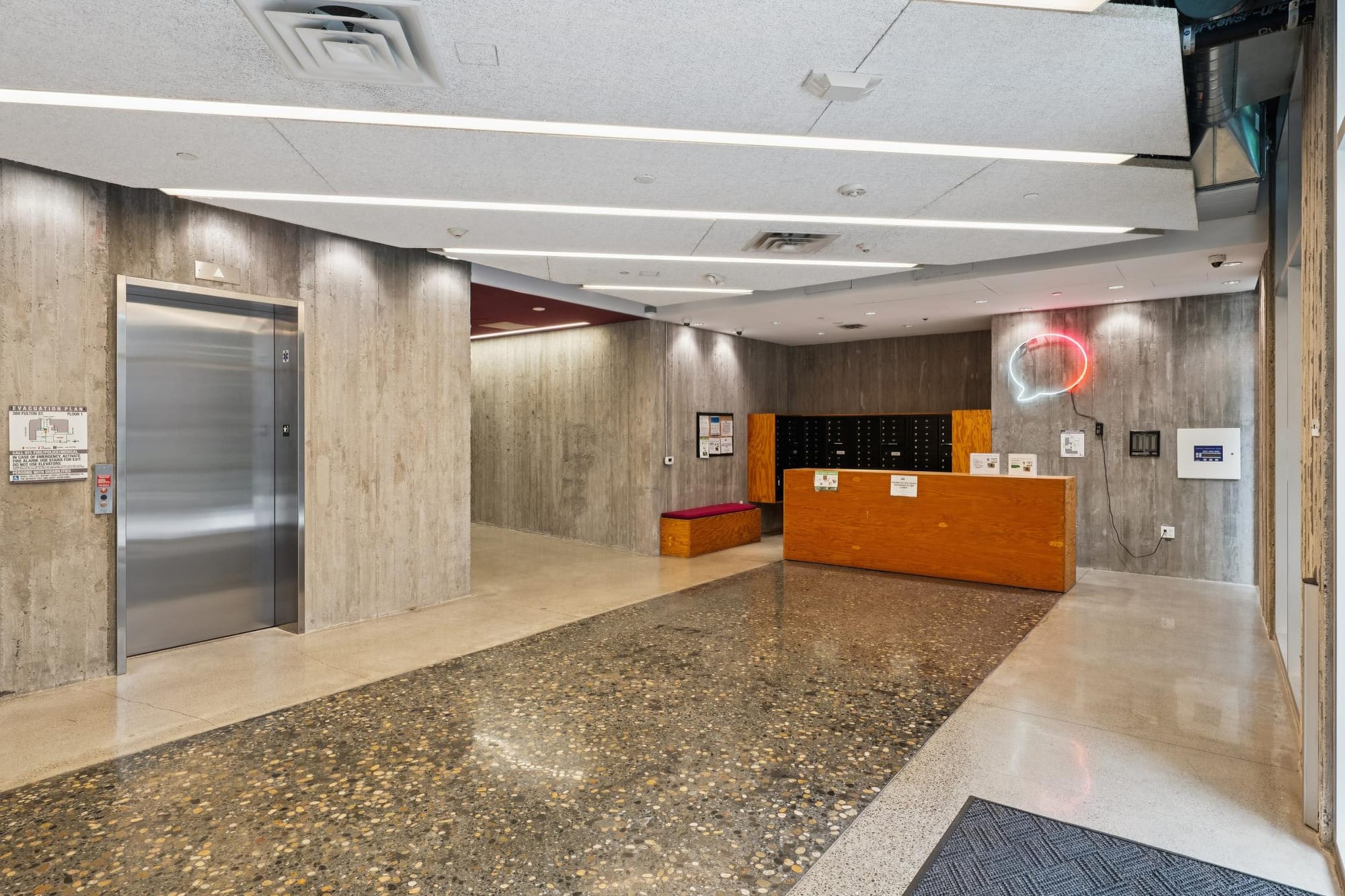 Board-formed concrete lobby with elevator at 388 Fulton