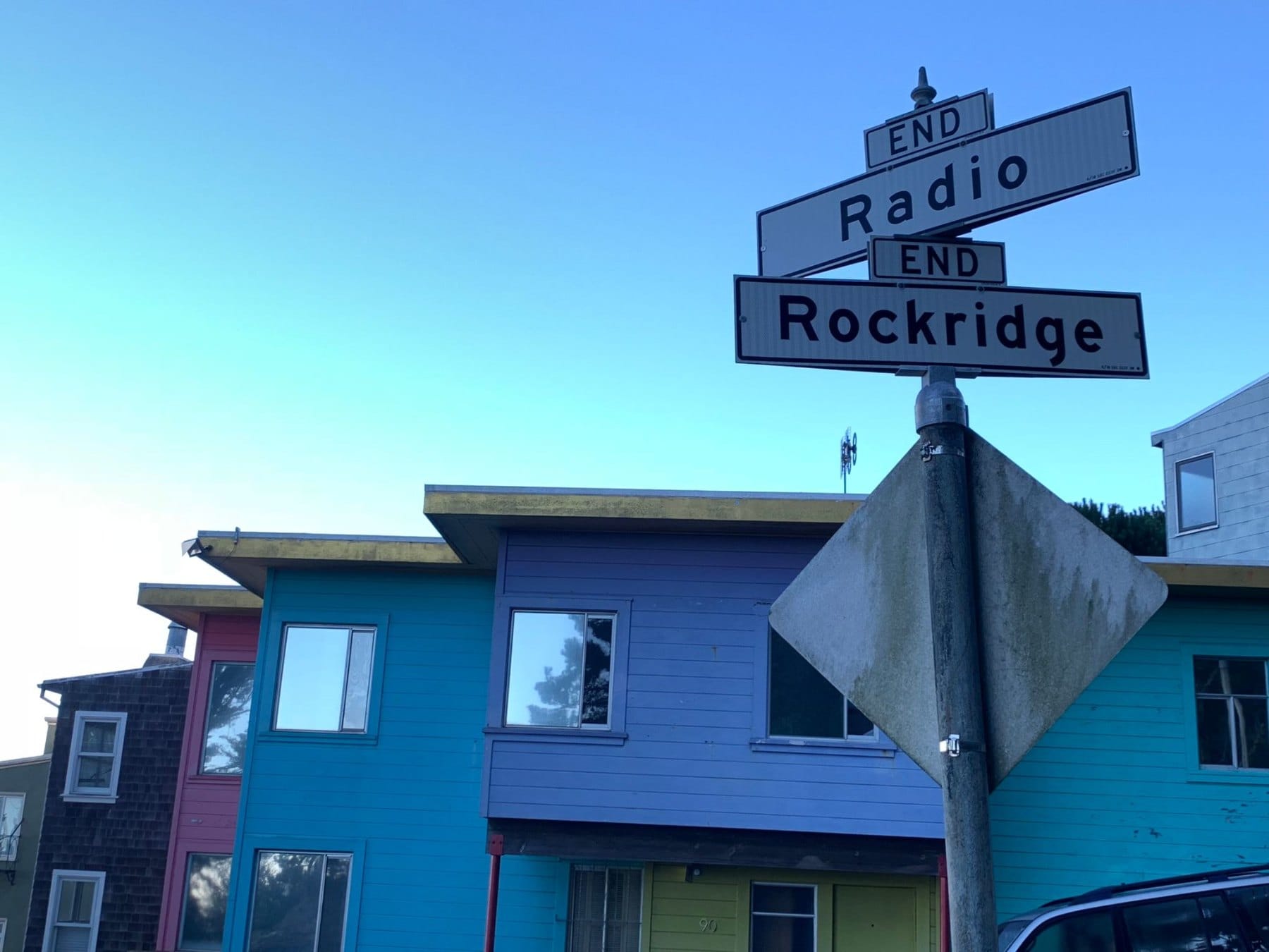 Radio and Rockridge street signs above colorful homes