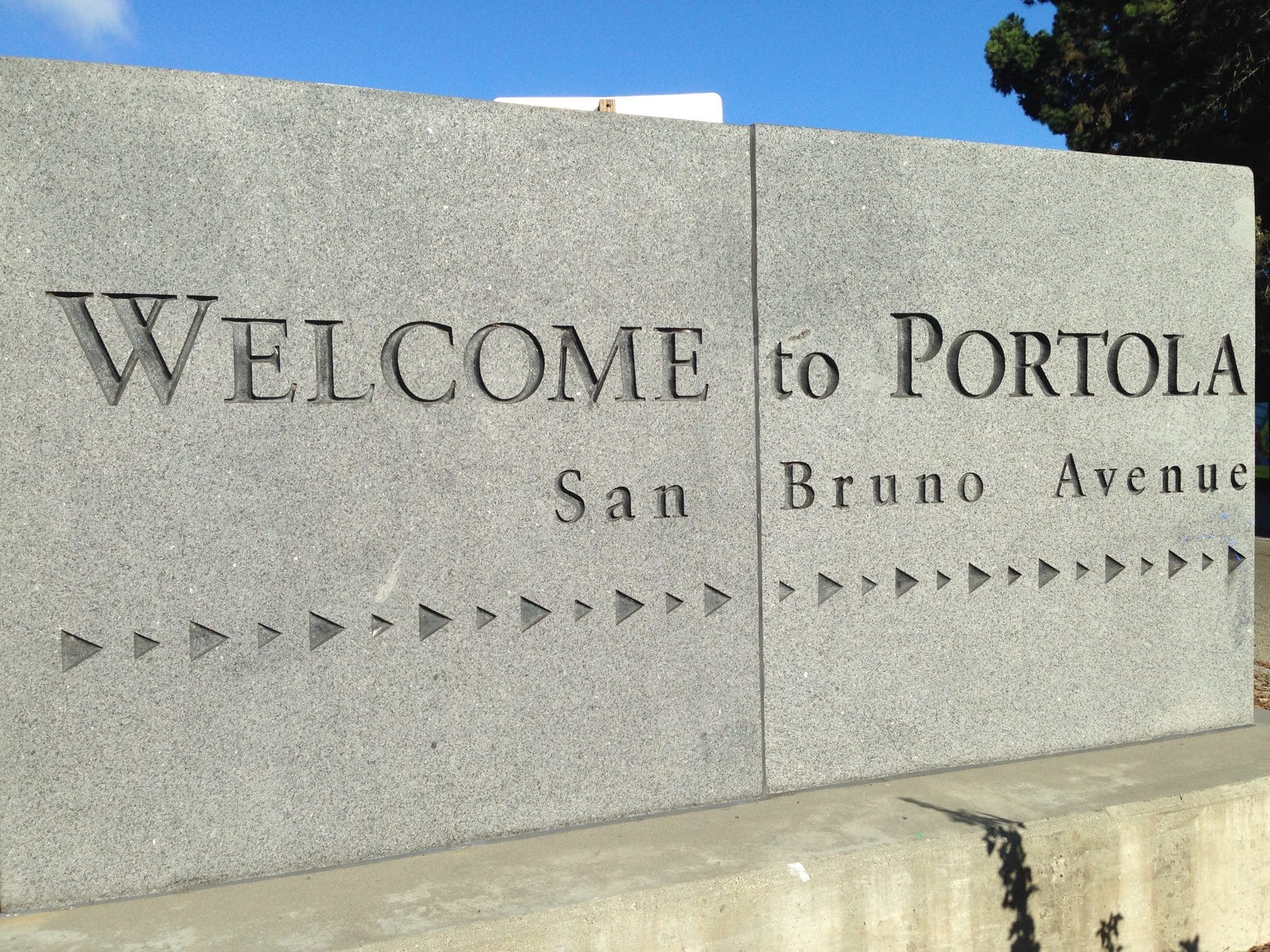 Stone sign reading Welcome to Portola, San Bruno Avenue