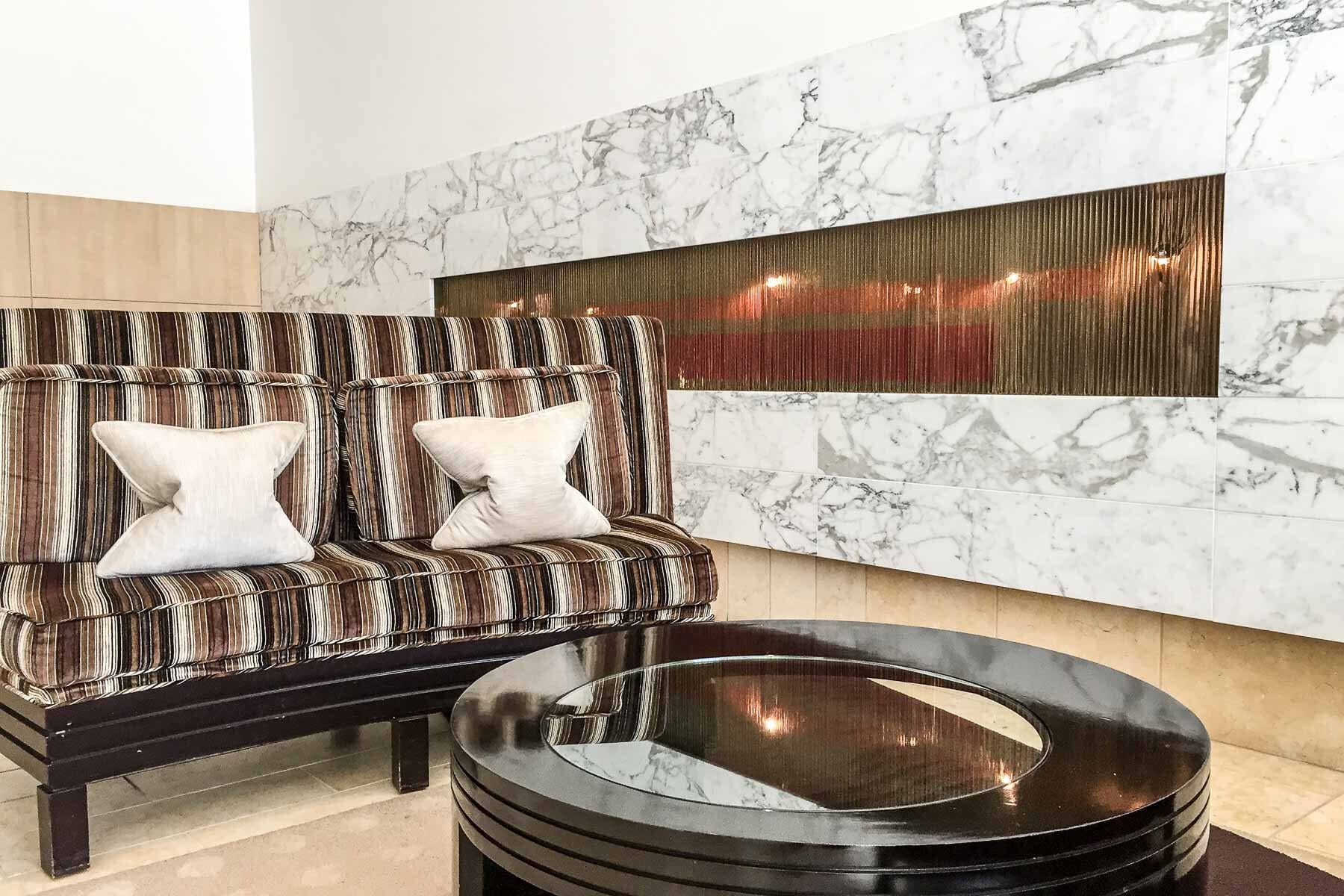 Striped lounge seating and a marble wall in the lobby lounge at SOMA Grand