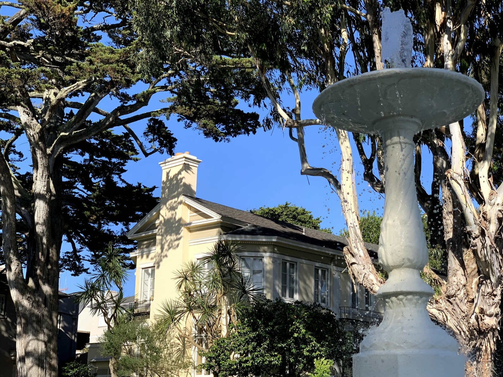 A fountain in front of a cream-colored house in St. Francis Wood