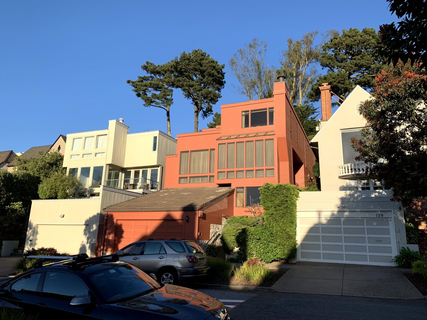 A modern orange-red house among older homes in St. Francis Wood
