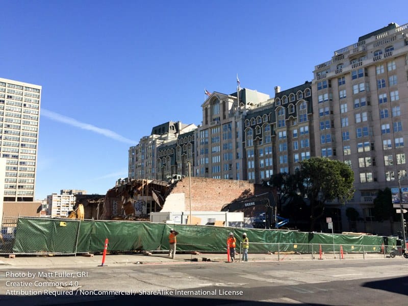 The old auto-shop brick fronts on Pine Street being braced during demolition, with San Francisco Towers behind