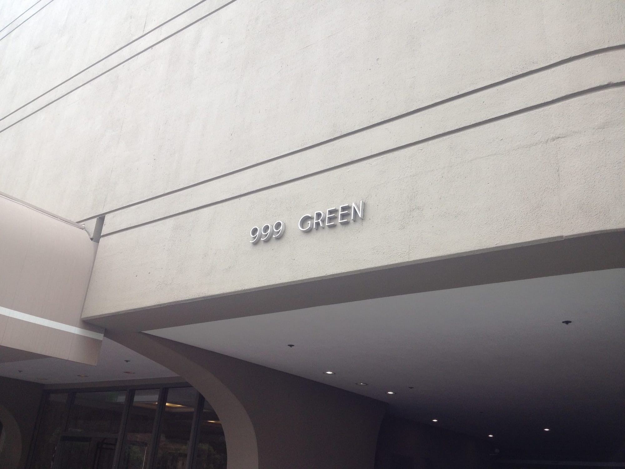 The 999 Green entrance under the curved concrete canopy