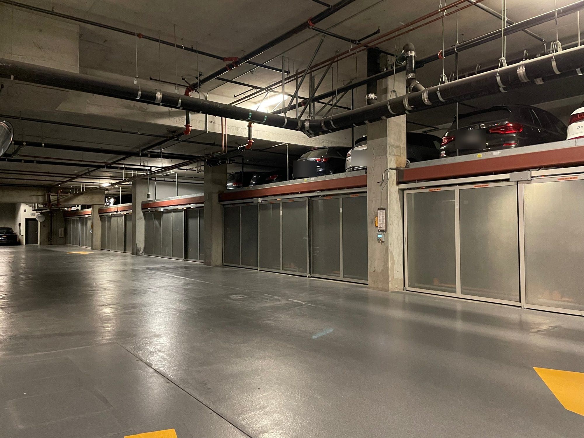 Glass-fronted puzzle parking lift in a San Francisco condo garage