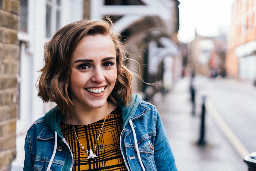 This is a photo of Hannah smiling on a street'