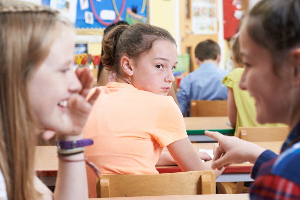 A young girl in school looking anxious