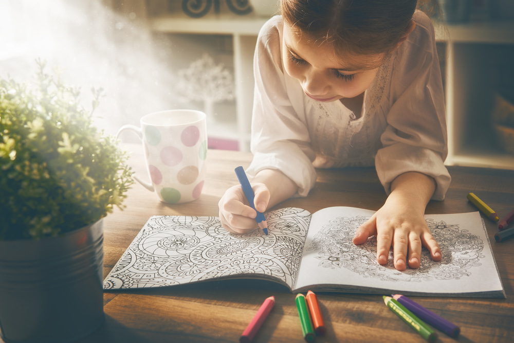 young girl colours on diningroom table