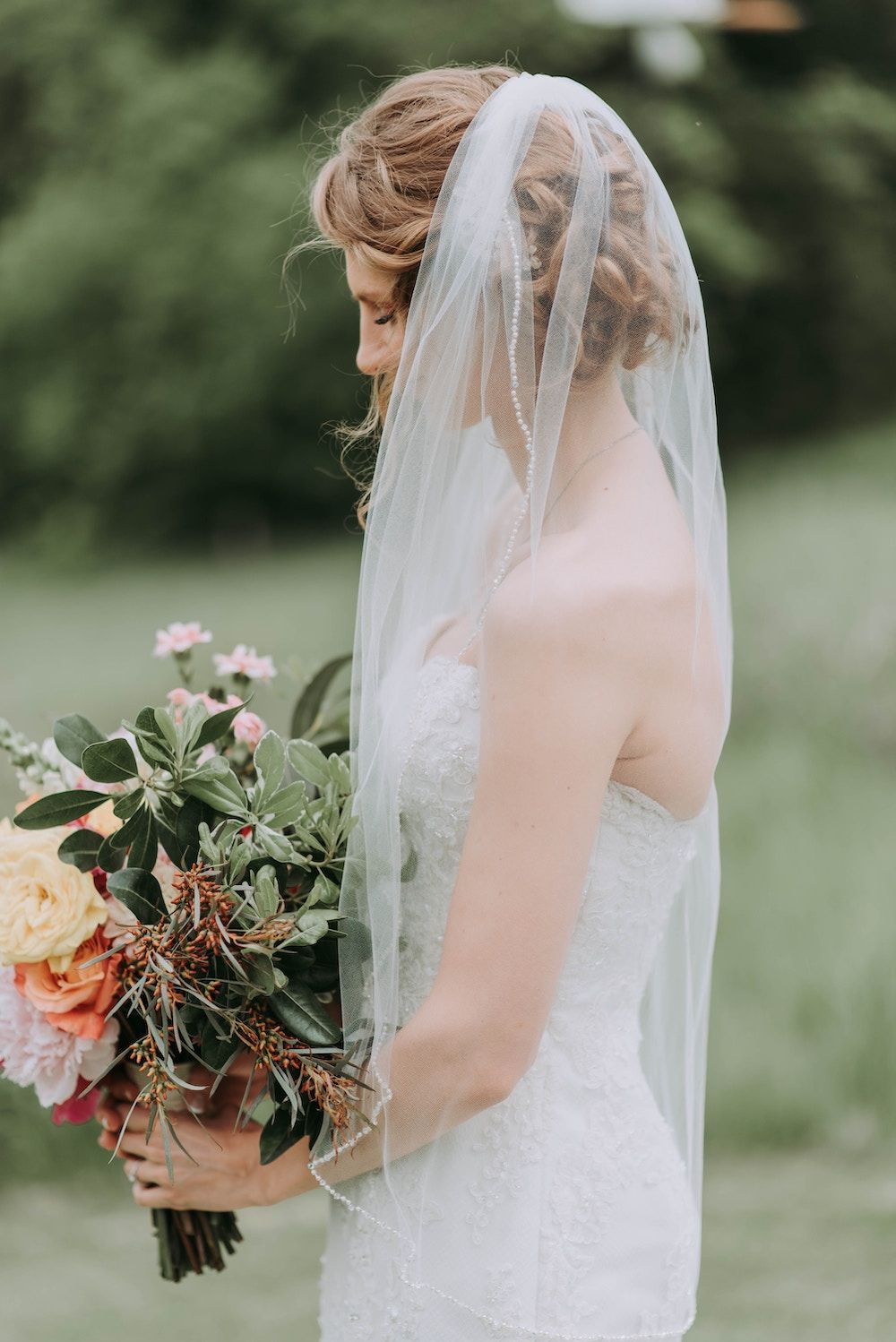 bride wearing veil and holding bouquet