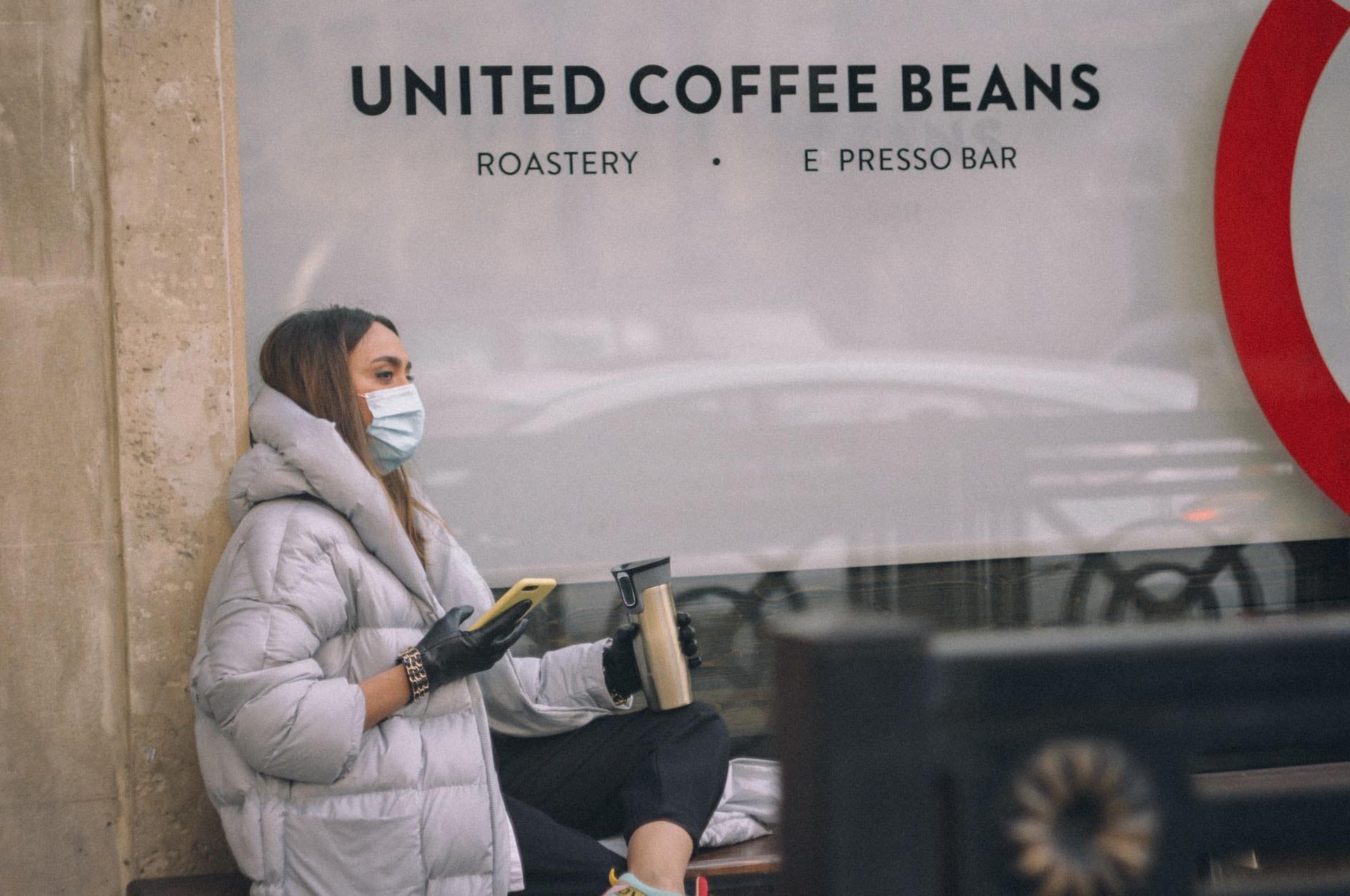 Woman-drinking-coffee-in-a-mask
