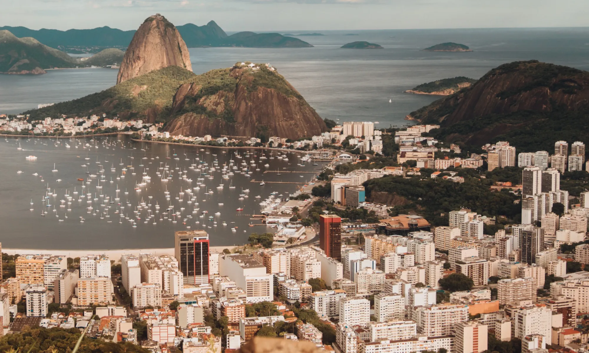 Aerial view of Rio de Janeiro, Brazil, with Sugarloaf Mountain and Guanabara Bay filled with boats.