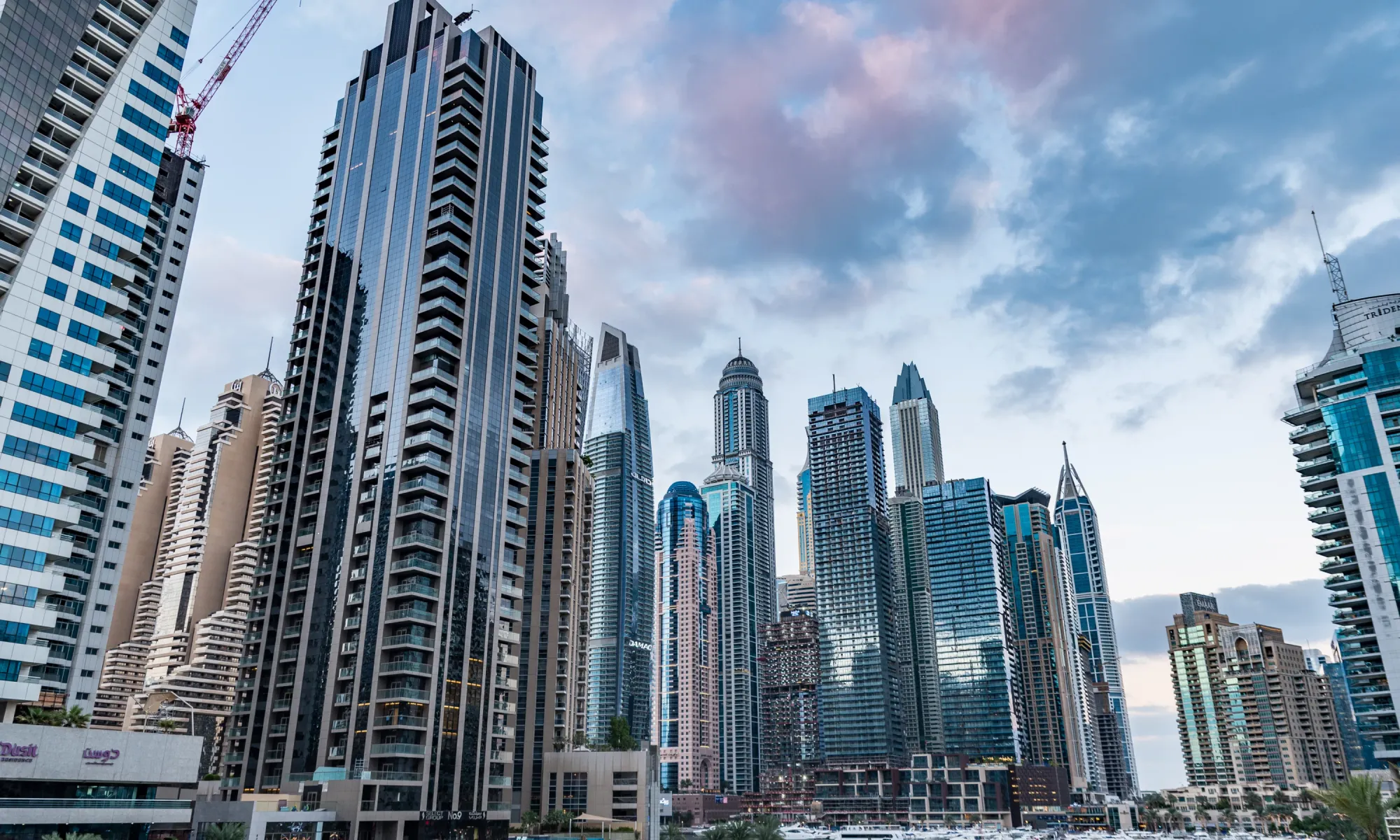 Skyline of Dubai Marina with futuristic high-rise buildings and skyscrapers at dusk.