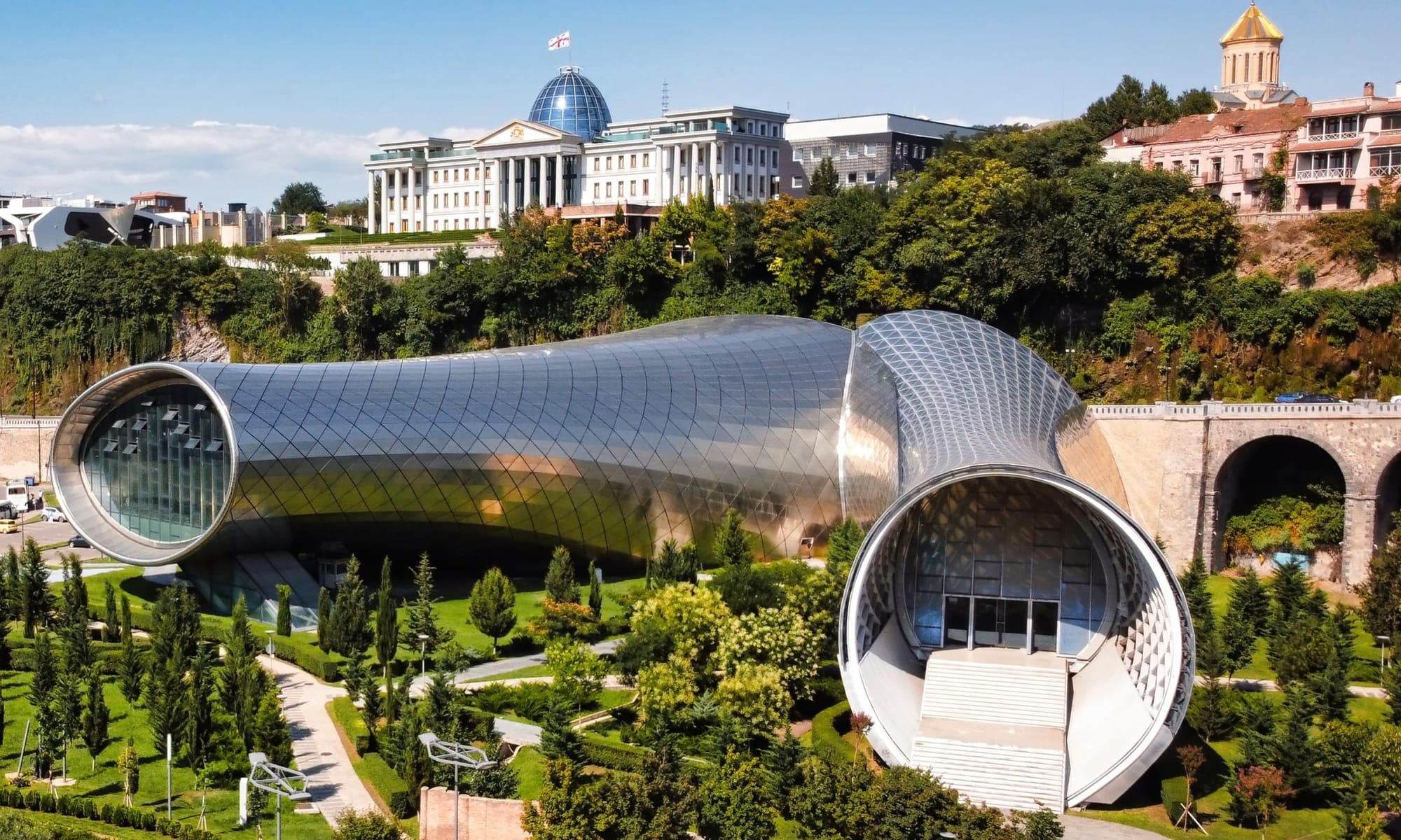 Contemporary architecture in Tbilisi – The modern, futuristic Rhike Park Concert Hall and Exhibition Center in Tbilisi, with the Presidential Palace in the background.