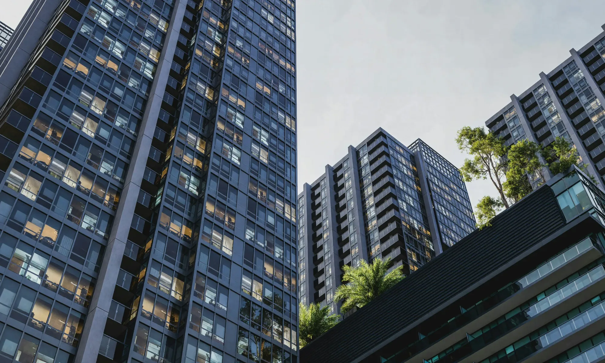 Modern residential and office high-rises with greenery and trees integrated into the architecture.